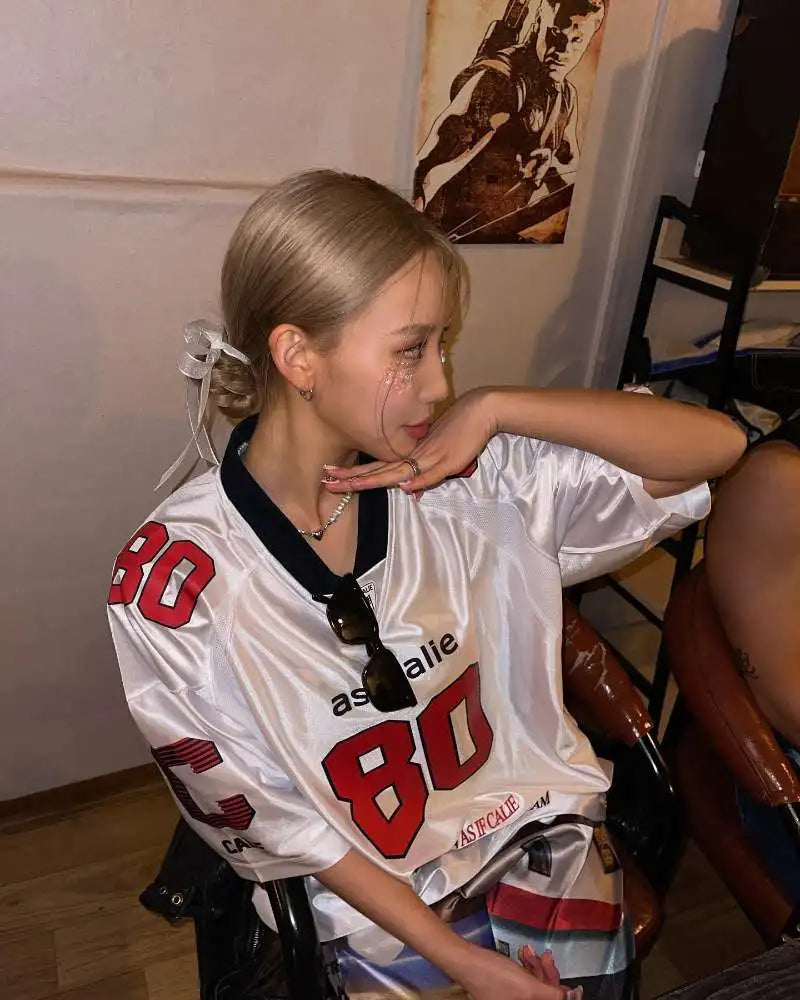 Minji Hyein ugyanazon Asif Calie koreai tervező márkájú, nyomtatott, laza, rövid ujjú mez felsőrész, nyári női túlméretezett sportpóló